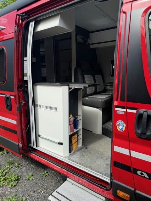 Interiør i campervan med kjøkken og sitteplass